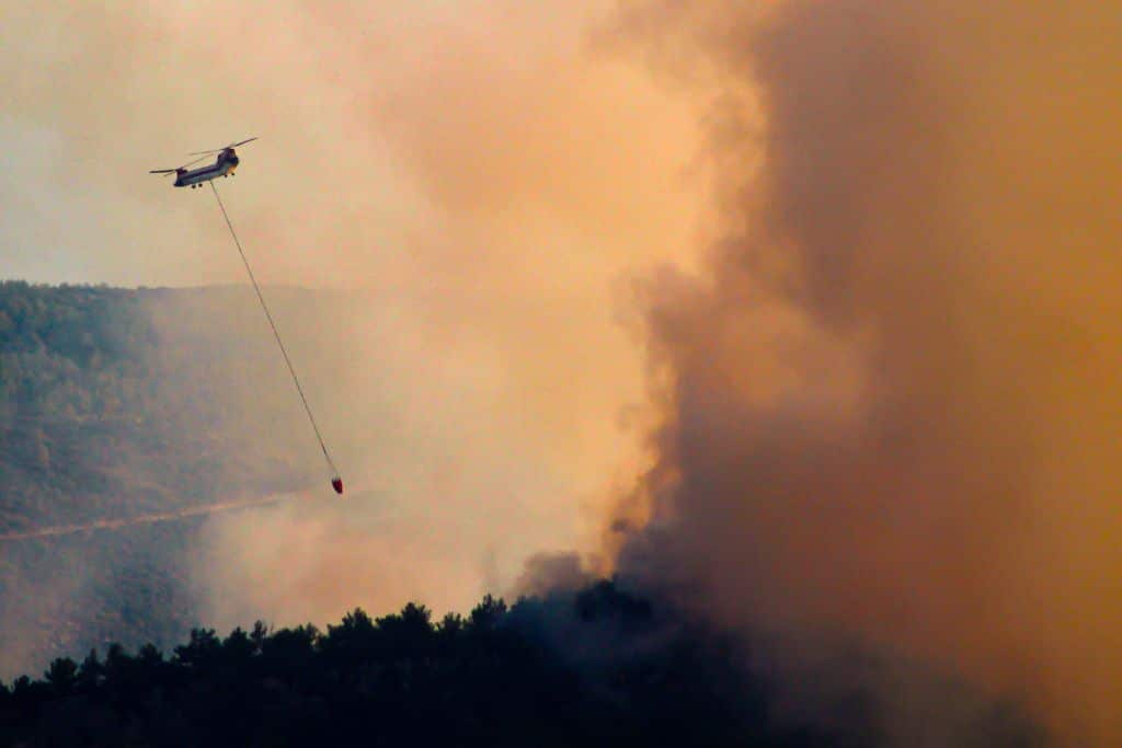 A helicopter extinguishing fire with water drops. Mugla region, 2022 Photo: Utku Kuran