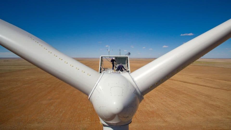 Two O&M wind technicians secure themselves with security harnesses to the top of a wind turbine during annual inspection of the Roosevelt wind farm in eastern New Mexico. Photo taken in May 2016