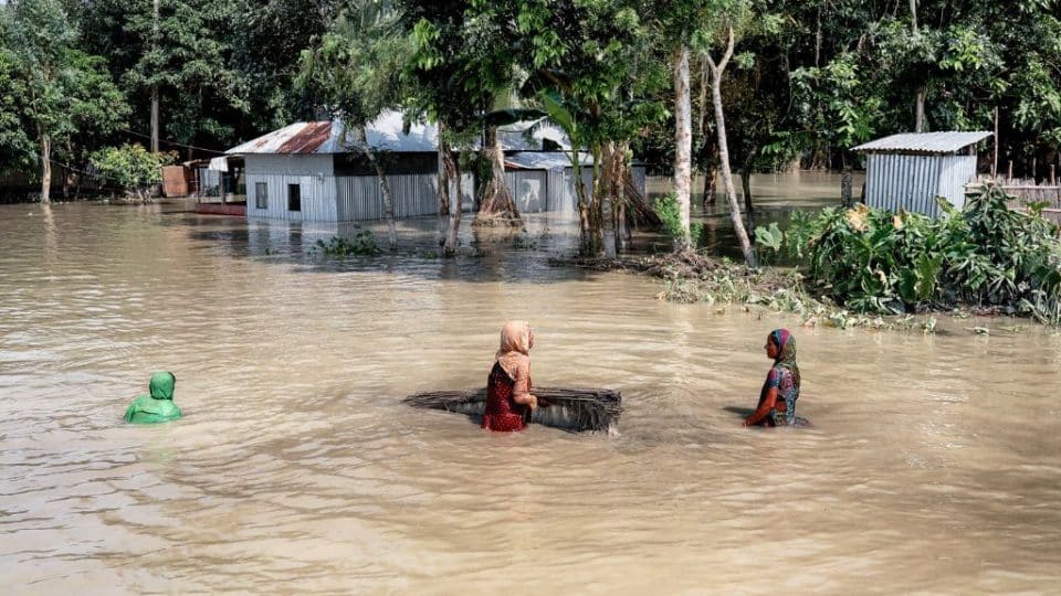 Women walking in floodwater during the Bangladesh flooding in 2019.