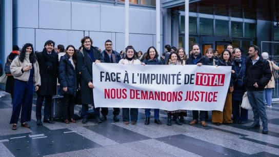 Activists stand in front of the Paris Court of Justice on February 19 as hearings for a climate case against TotalEnergies begin.