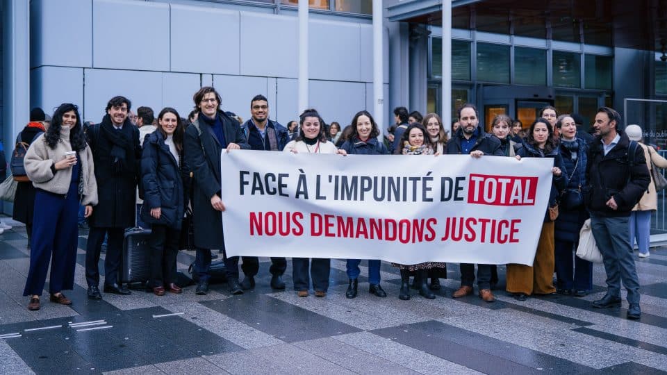 Activists stand in front of the Paris Court of Justice on February 19 as hearings for a climate case against TotalEnergies begin.