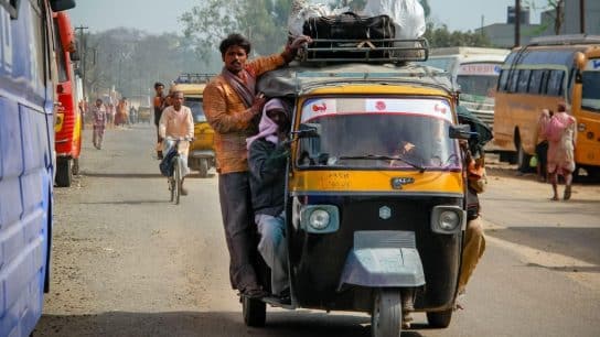 Men on a three-wheeler in India on a hot day.