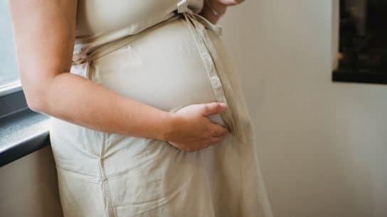 A pregnant woman holding her belly.
